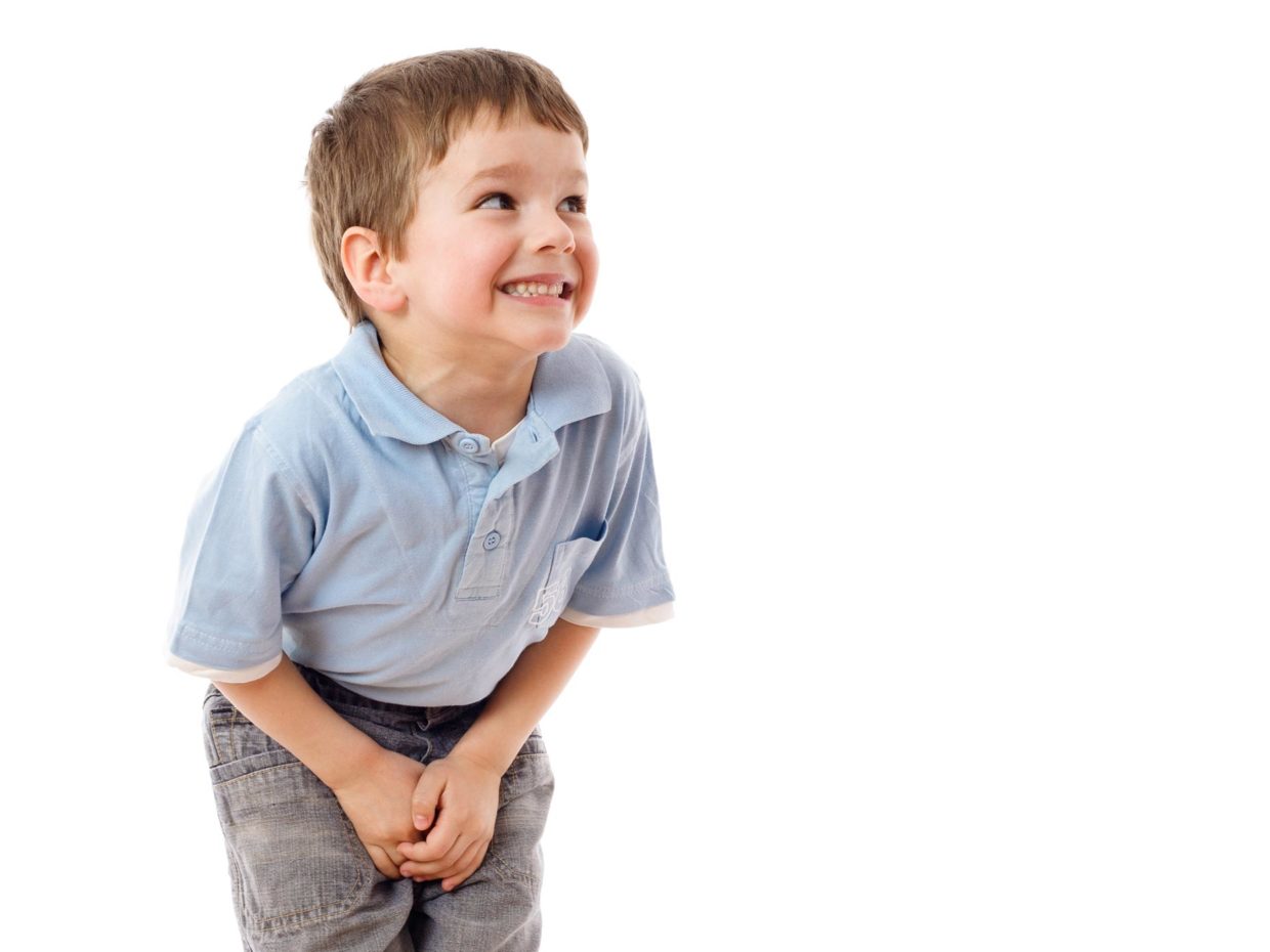 bambino sorridente su sfondo bianco piegato in avanti