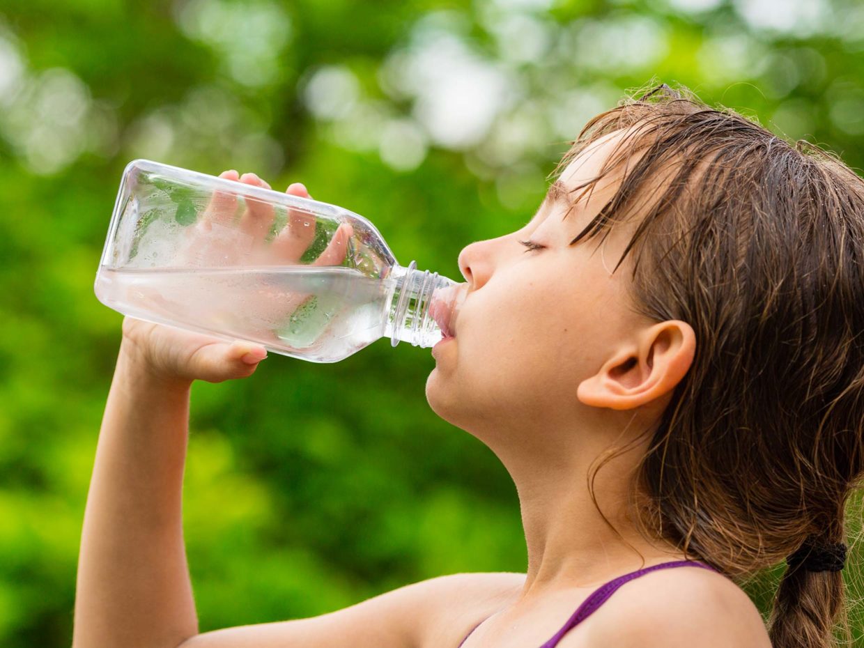bambina sudata beve acqua dalla bottiglia