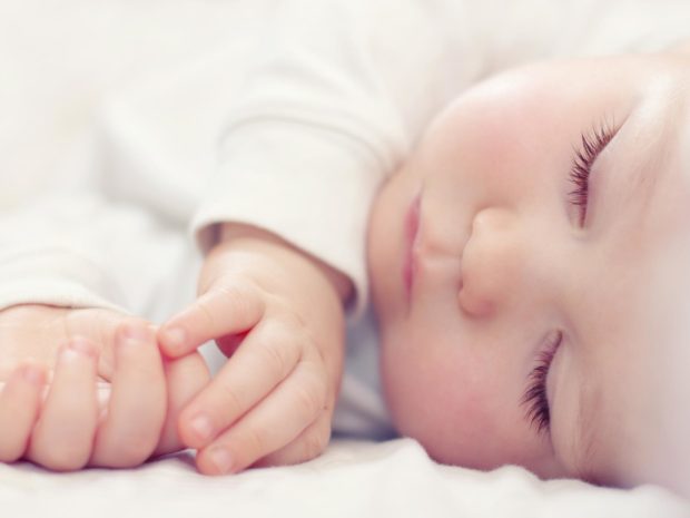 primo piano su un neonato che dorme sul fianco