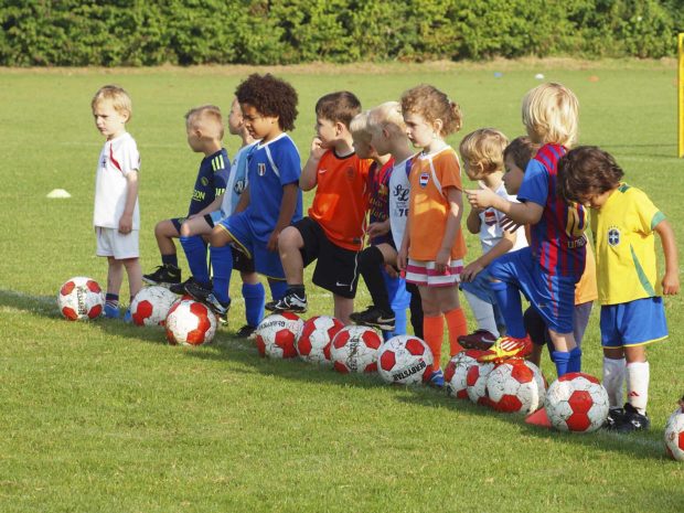 bambini in fila su campo da calcio durante un allenamento