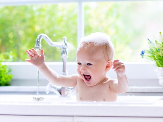 bambino felice con la schiuma in testa durante il bagno