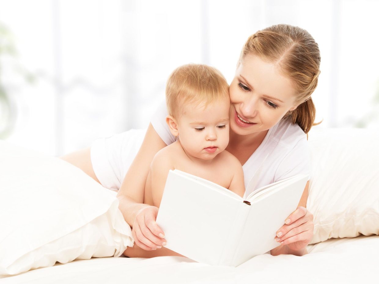 mamma guarda libro insieme al suo piccolo bambino