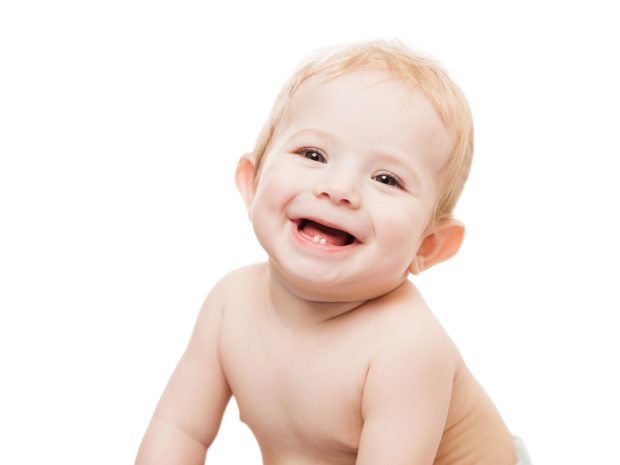 neonato sorride mostrando i primi denti da latte