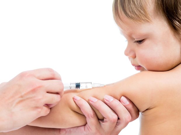 bambino guarda mentre viene vaccinato al braccio