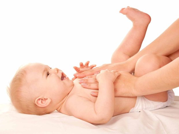 genitore massaggia la pancia del neonato