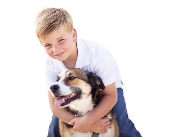 bambino biondo abbraccia da dietro cane di grossa taglia