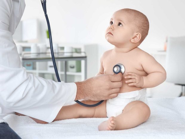 bambino guarda pediatra che ausculta i suoi battiti con lo stetoscopio